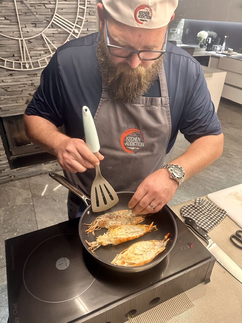A guest proudly presenting the meal he prepared in class